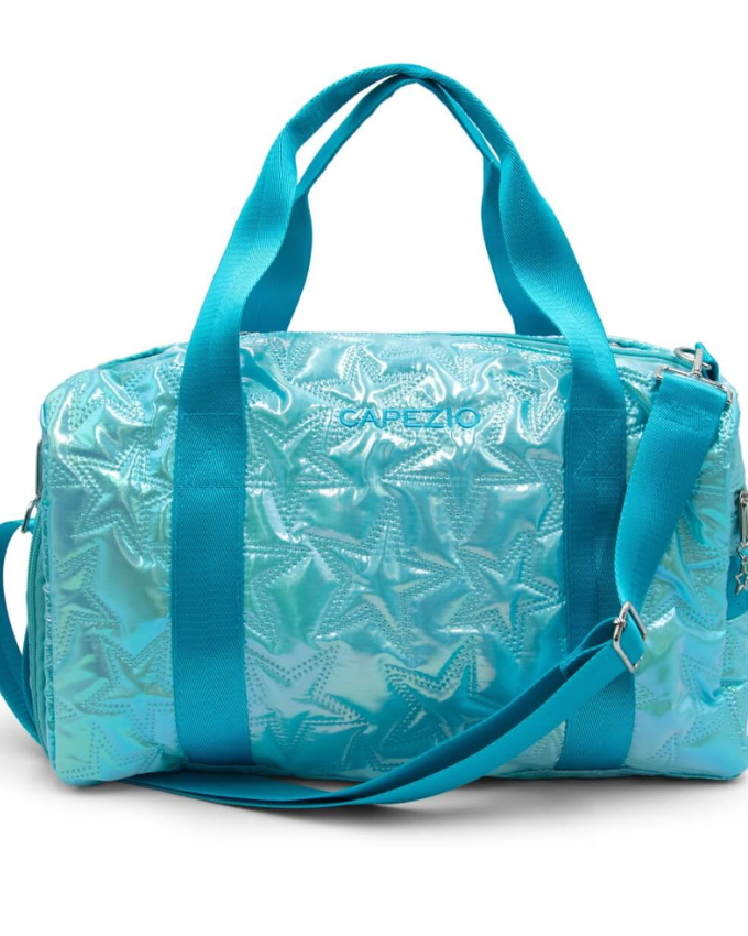Iridescent turquoise star design travel duffle bag with tote shoulder straps, an adjustable and detachable shoulder strap, and a Capezio logo on the side.