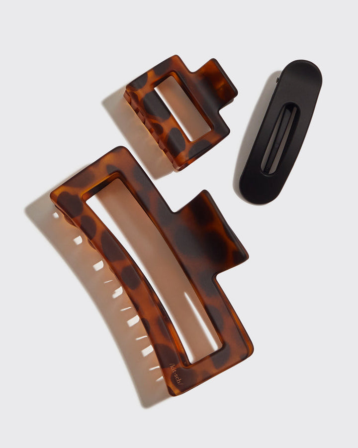 Two tortoiseshell patterned hair clips and a flat black clip.