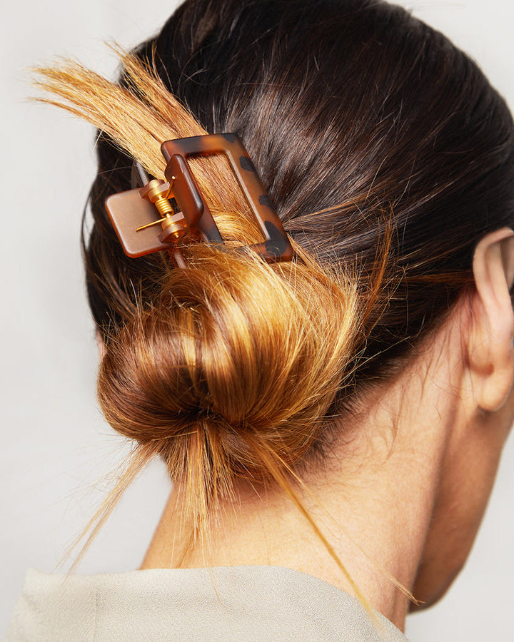 Close-up of a medium tortoise patterned hair clip holding back a bun.