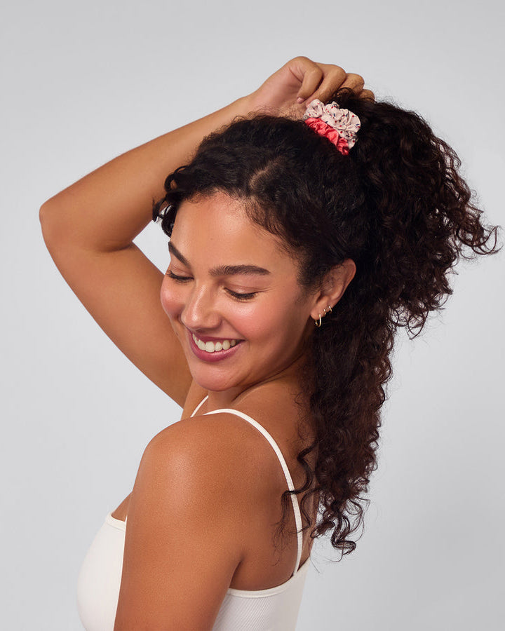 Woman with thick curly ponytail tied up with scrunchies.