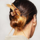 Close-up of a medium tortoise patterned hair clip holding back a bun.